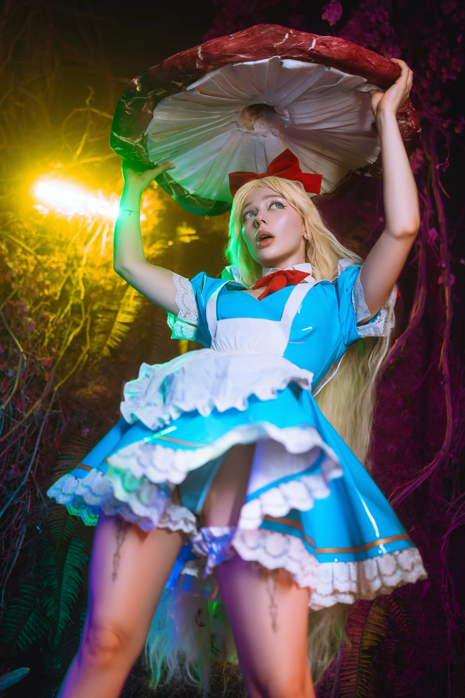 Ira as Alice in a blue dress in a fantasy woodland set